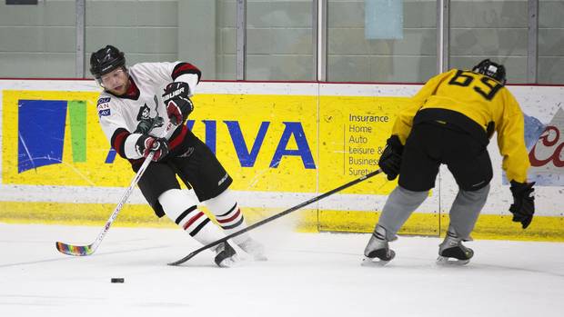 Justin Connelly (left) handles the puck in his hockey game with the Calgary Pioneers in Calgary on Dec. 3, 2016. The Calgary Pioneers are the only gay men's hockey team in Alberta. 