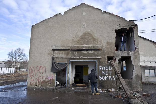 A migrant stands by a hole in an abandoned warehouse in Belgrade, where he and others have taken refuge.