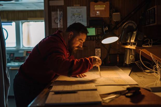 On the bridge, first mate Jim Pierce of Nova Scotia studies a map of eastern Lake Ontario.