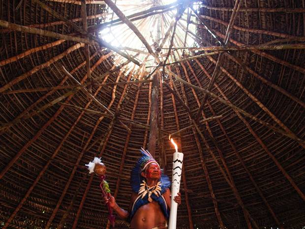 Dessana indigenous shaman Raimundo Dessana holds the Olympic torch during a ritual at the Tupe Reservation in the outskirts of Manaus, Brazil on Monday.