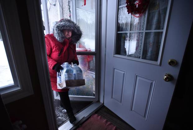 Serpent River First Nation Chief Elaine Johnston brings some bottled water to her parents' home on Dec. 20, 2016.