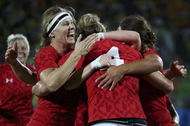 Canadian rugby player Kelly Russell celebrates with teammates after scoring.