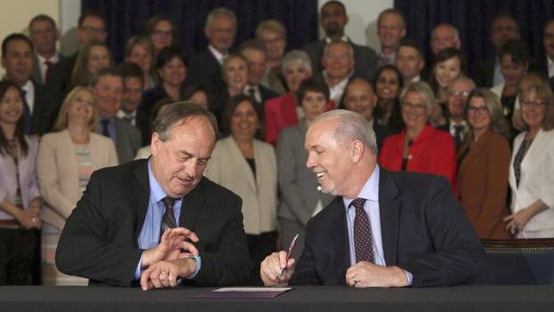 NDP leader John Horgan, left, and his Green Party counterpart Andrew Weaver at the May 30 signing of their pact.