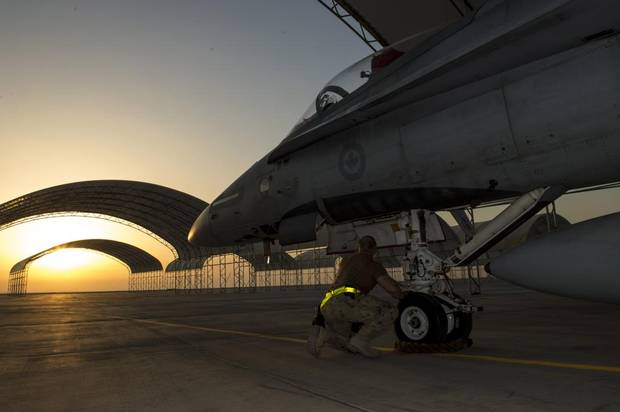 An aircraft technician from Air Task Force – Iraq inspects the nose landing gear of a CF-188 Hornet aircraft at the Camp Patrice Vincent flight line, in Kuwait during Operation IMPACT on December 11, 2015.