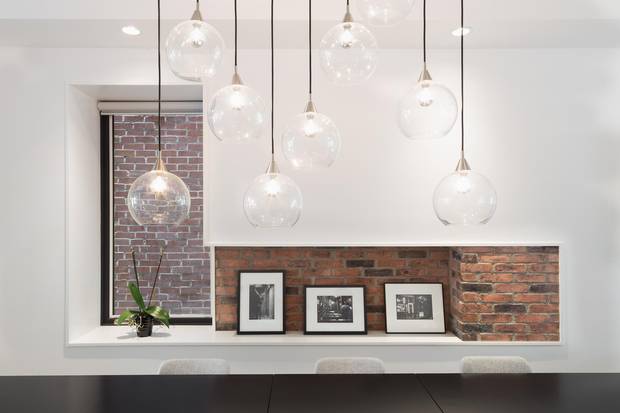 A faux-exposed brick feature blends into a deeply-silled window near the dining room.