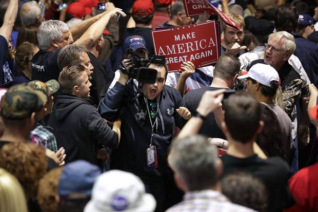 CNN's Noah Gray is shoved and shouted at by Trump supporters as he trys to cover breaking news at the Reno rally. Mr. Trump got hustled off-stage during a disturbance at the rally; someone in the crowd shouted “Gun!” during scuffles with a man who was holding up a “Republicans against Trump” sign.