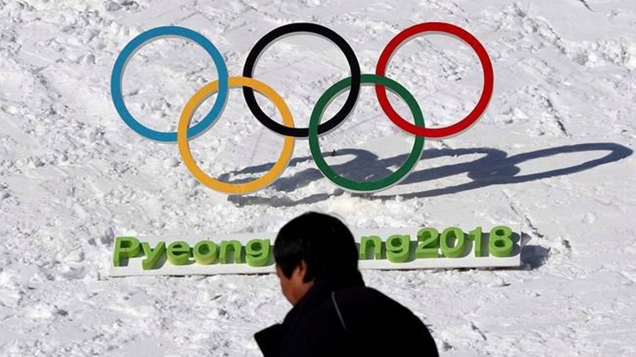 A man walks by the Olympic rings in Pyeongchang.
