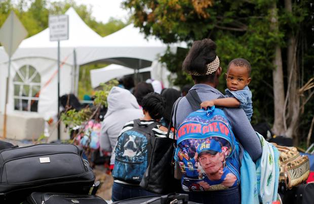 A line of asylum seekers who identified themselves as being from Haiti wait to enter into Canada from Roxham Road in Champlain, New York.
