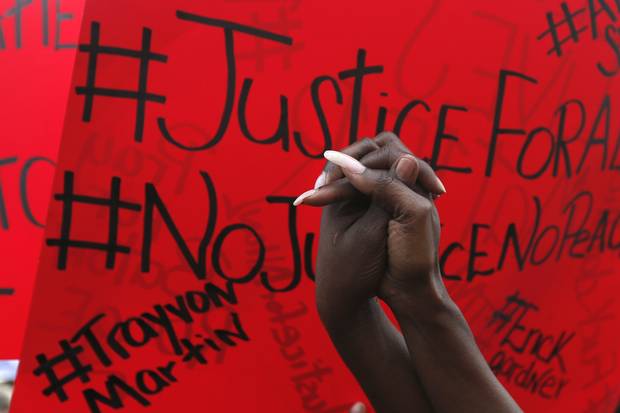 People hold a vigil outside the Triple S convenience store in Baton Rouge, La., on July 6, 2016. Alton Sterling, 37, was shot and killed outside the store by Baton Rouge police, where he was selling CDs.