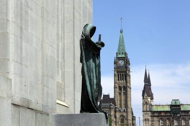 Ottawa’s Parliament buildings loom behind the statue of Ivstitia (Justice) on the front steps of the Supreme Court of Canada.