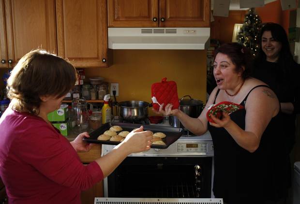 Merell Awad jokes about the Ma'amouls, a date-filled cookie, with her sisters Rania, left, and Huda.