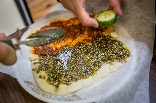 TORONTO, JULY 21, 2017 - BEROEA BOX - Syrian immigrants to Canada, Amir Fatal and his wife Nour Ammana share their Halabi cuisine with the people of Toronto through their catering service and from a shipping container restaurant called the Beroea Box, found outside the Scadding Court Community Centre at the corner of Dundas Street West and Bathurst Street in Toronto. Beroea menu items include a flatbread called Manúshe which comes in several varieties such as Zaatar with a number of traditional toppings including dried thyme, sumac and sesame seeds mixed with olive oil and Mouhamara with Aleppo’s original sweet red pepper paste, (also made as a half and half, as seen here).