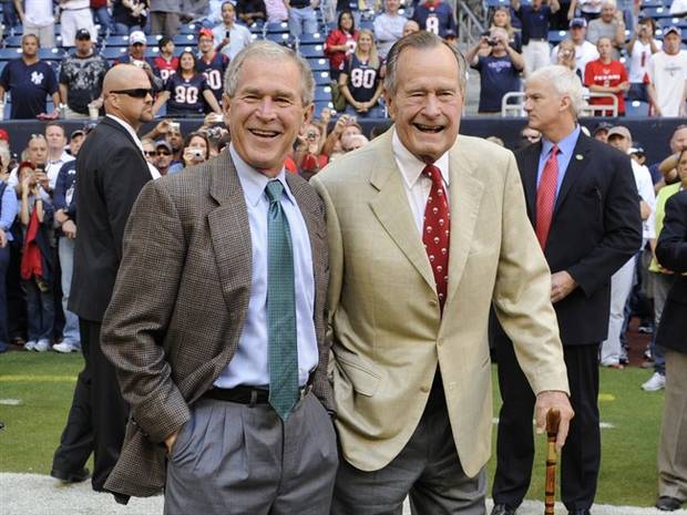 Presidents George H. W. Bush, right, and George W. Bush before the Houston Texans NFL football game against the San Francisco 49ers in Houston in 2009. 
