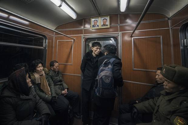 Locals, including a soldier, catch some sleep on their evening train ride home. North Korean law requires that matching portraits of former leaders Kim Il-sung and Kim Jong-il hang at the end of every metro car, as well as in every home, school and workplace in the country. The ever-present personality cult has a sedating effect on city streets, with noise rarely rising above a low thrum.