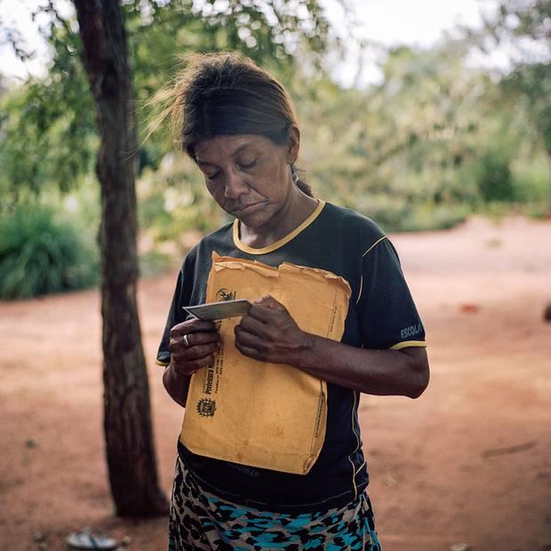 Maria Benites looks at a photo of one of the two sons she lost to suicide.