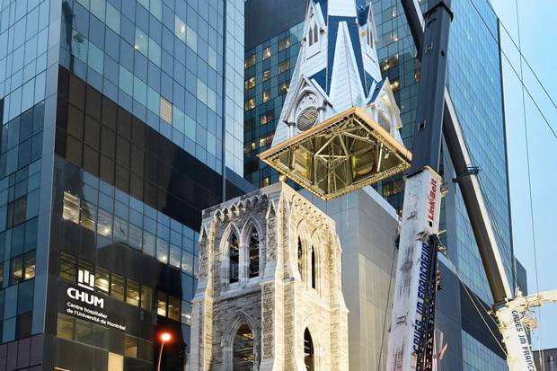 A crane places the spire on a steeple at one of the entrances of the University of Montreal’s hospital centre.