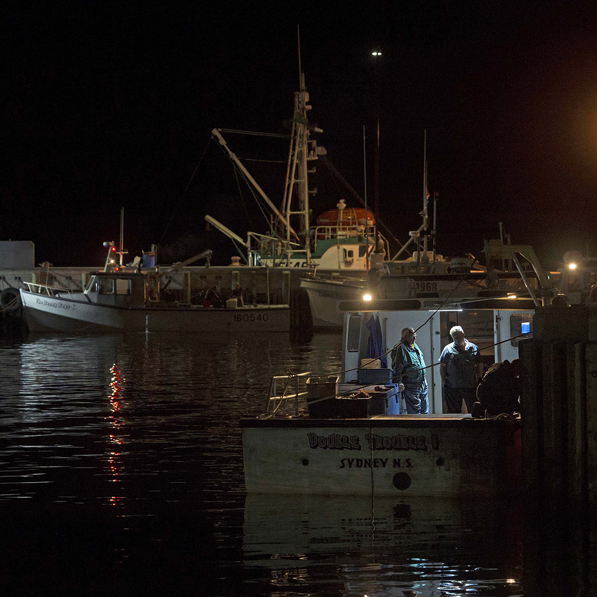 Crab harvesters at the wharf in the early hours of the season's first day in Cheticamp, N.S. on July 14, 2017. Conditions are calm, but even so, the dangers are ever-present.