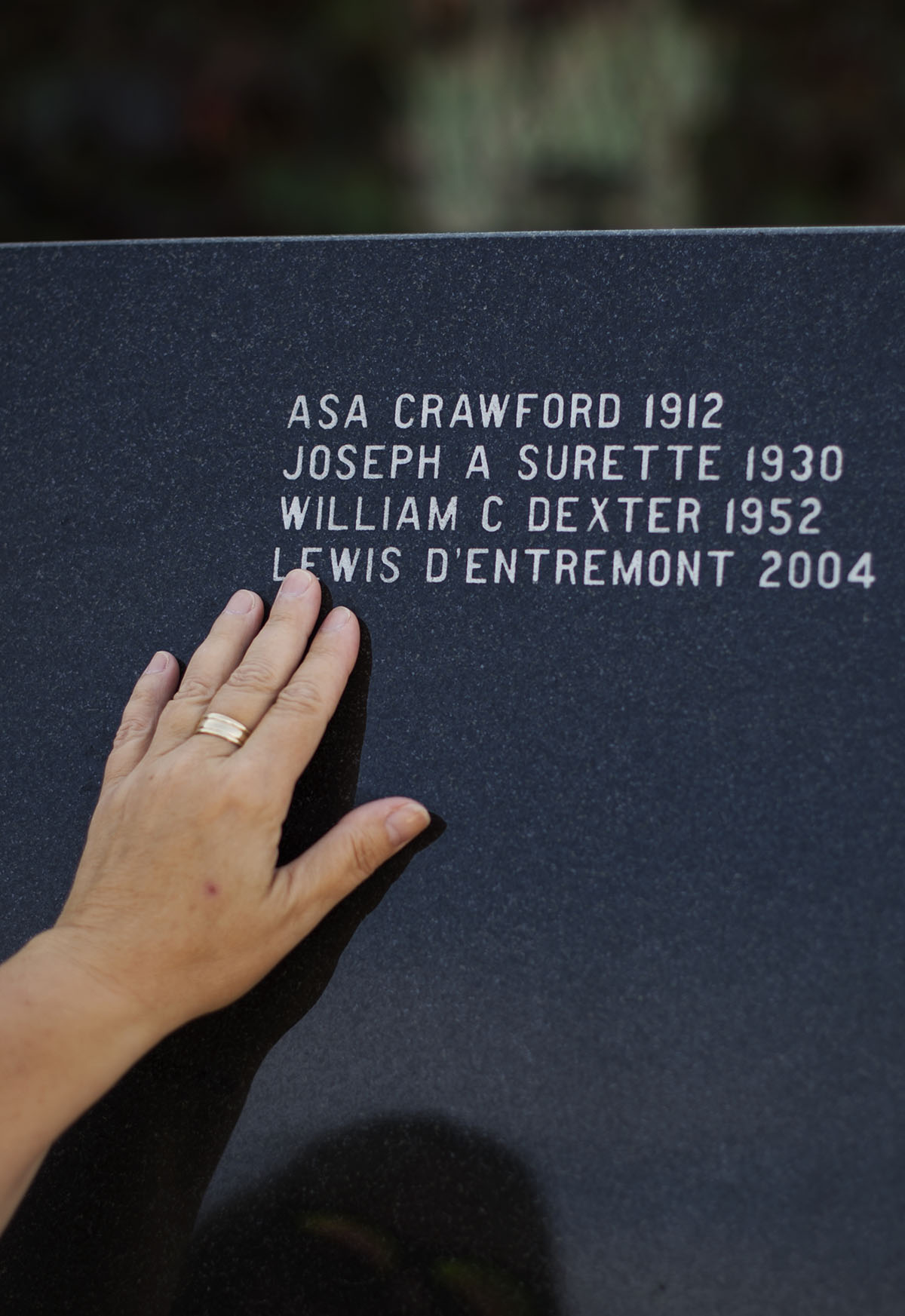 Marilyn D’Entremont runs her hand over her late husband’s name at a memorial for those ‘Lost to the Sea’ in Yarmouth, N.S.