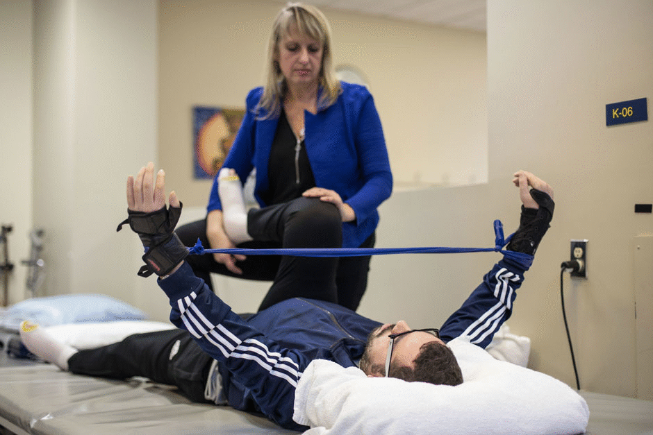 Mr. Derbali stretches his arms during physical therapy at the Institut de réadaptation en déficience physique de Québec.