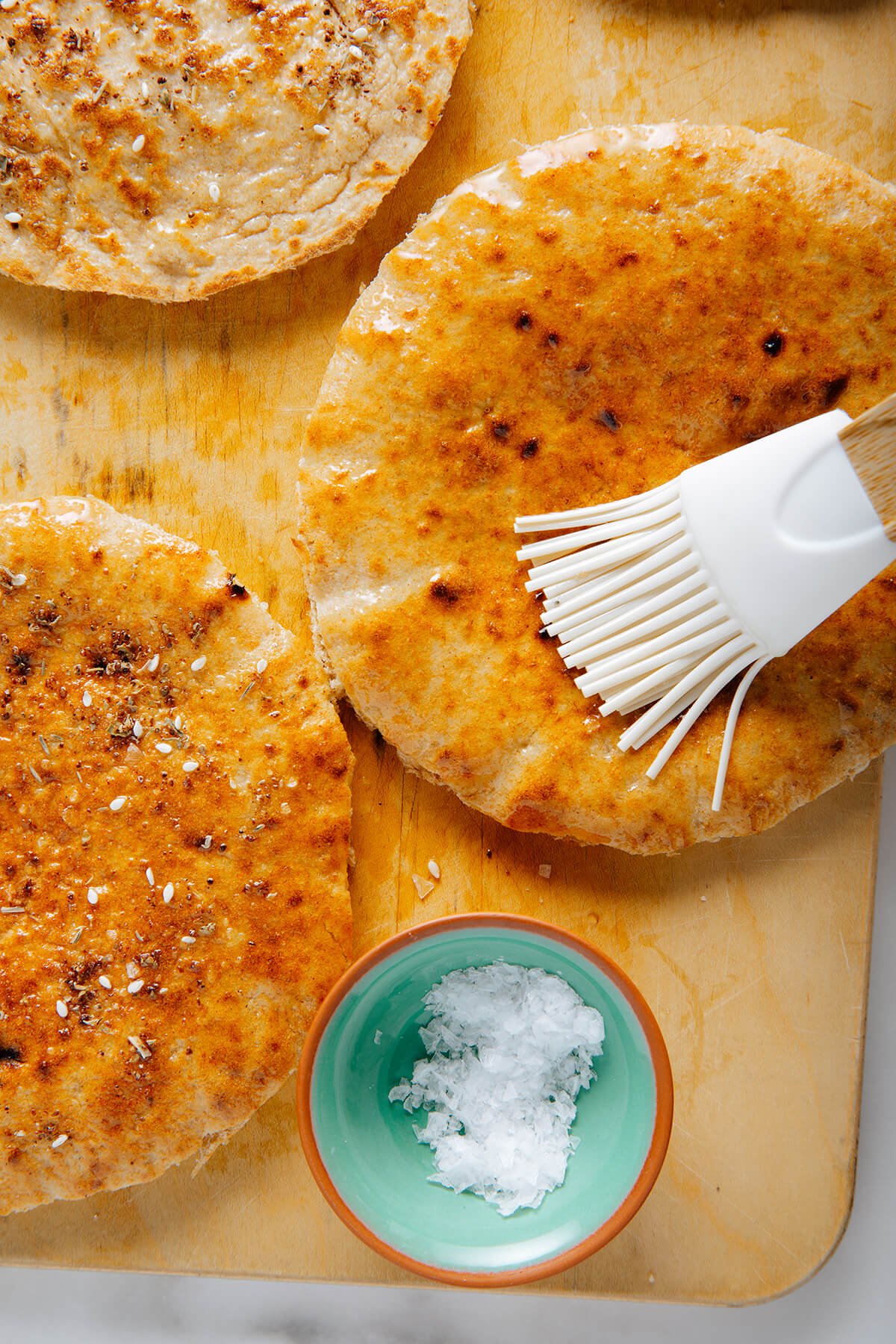brushing pita bread with olive oil