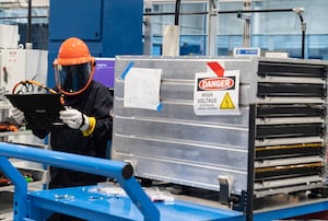 A worker installs an installation plate into a battery pack at Lion Electric Company's lithium-ion battery manufacturing facility in Mirabel, Que., Thursday, Sept. 14, 2023.  THE CANADIAN PRESS/Christinne Muschi