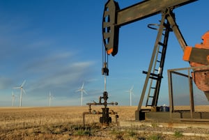Taber Wind Farm, 20 km southeast of Taber, AB. Oil derrick in foreground, windmills in background. Alberta's "traditional" energy economy meets the new world order. Derrick makes a lot of noise - has an engine, clacks and clunks away, you can hear it a long way off. The wind turbines are almost completely silent, by comparison, even though they are 300x the size.  
Sept. 2007
Photo by Ashley Bristowe