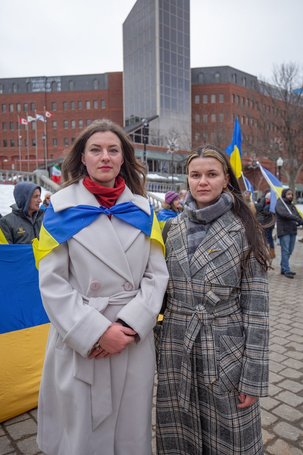 Event organizers Maryna Horobets (left) and Marianna Kovtun(right) stand in front of a large Ukrainian flag among many powerful signs calling for peace and the protection of children at the Rally for Ukraine at Grand Parade in Halifax, Nova Scotia. (Aly Ambler/ The Globe and Mail)(02/22/2026)