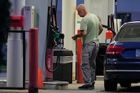 A customer checks on gas price at a gas station in Buffalo Grove, Thursday, June 25, 2026. (AP Photo/Nam Y. Huh)