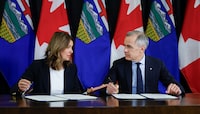 Prime Minister Mark Carney, right, signs an MOU with Alberta Premier Danielle Smith in Calgary, Thursday, Nov. 27, 2025. THE CANADIAN PRESS/Jeff McIntosh