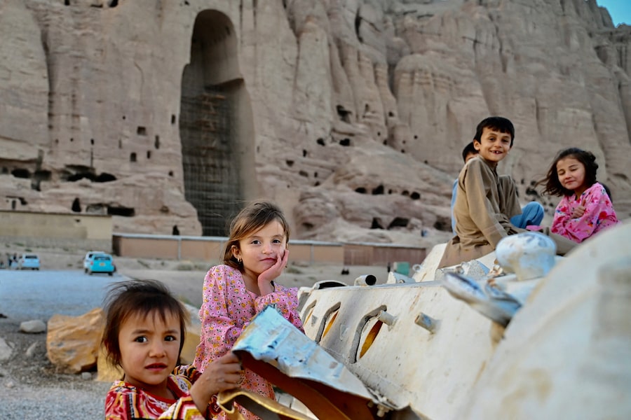Afghan children play atop a Soviet-era military tank in Afghanistan’s Bamiyan province on July 22, 2026, near the site of giant Buddha statues the Taliban destroyed in 2001.
