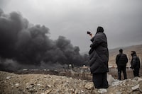 Plumes of smoke rise over oil depot tanks hit by joint Israel-U.S. strikes overnight north west of Tehran, Iran on March 8.