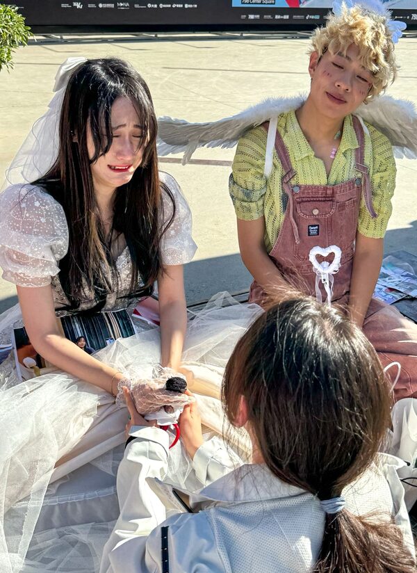 Newly divorced Qian Jin (left) is overcome with emotion as a participant in a divorce party put on by influencer Feng Xiaogang (right) cuts the hem of her wedding dress.