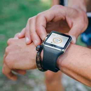 Unrecognizable sportsman looking at a smartwatch outdoors
