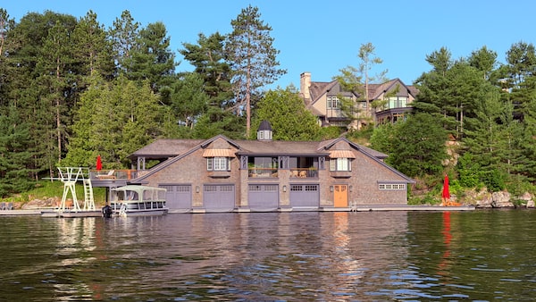Cruising by one of the boathouses on the Lake Rosseau estate belonging to Canadian billionaire Peter Gilgan. The Muskoka property served as the backdrop for the invitation-only Dock (un)Conference, which brought together leaders in business, technology and government, including Prime Minister Mark Carney, for discussions about Canada’s future.