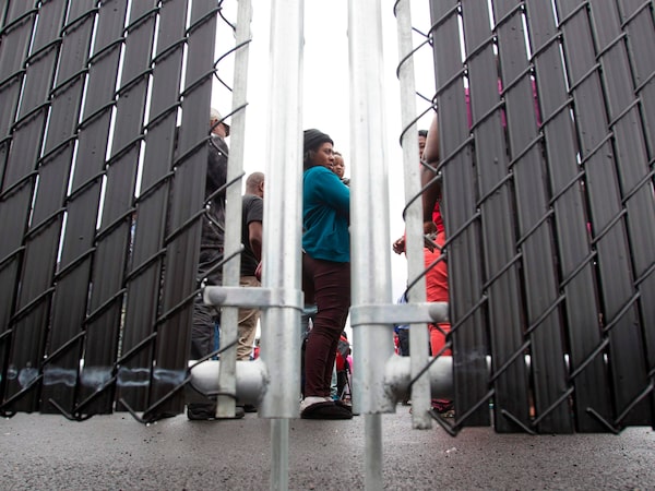  Refugees who made an irregular crossing at the Canada-U.S. border wait in a temporary detention centre in Blackpool, Que., in August, 2017.