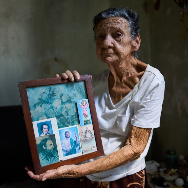 Mercedes Lopez Rey, 83, keeps a portrait of Fidel Castro alongside her prayer cards in Old Havana, where she lives. Life has been harder for seniors like her under an economic crisis and tensions with Washington.