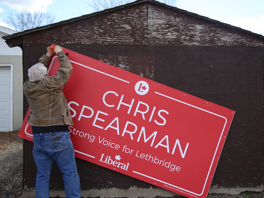 Lethbridge Liberal candidate Chris Spearman removes campaign signs on April 30, after losing his riding to a Conservative candidate.