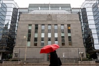 A person with an umbrella walks in front of the Bank of Canada building in Ottawa on Friday, Oct. 31, 2025. Keito Newman/The Globe and Mail
