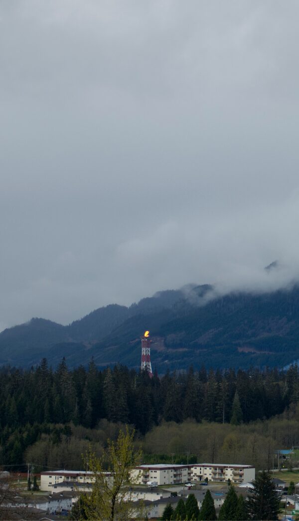 Flames rise from LNG Canada's flare tower and smoke from a Rio Tinto aluminum smelter rise over Kitimat, B.C. A new export terminal will open here later this spring, taking billions of dollars worth of fuel to markets beyond the United States.