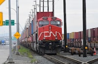A CN engine and railcars with containers sit near the Roberts bank Super Port,  in Delta, B.C., August, 2024.