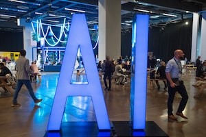 People walk past an AI sign at the All In artificial intelligence conference Thursday, Sept. 28, 2023 in Montreal.THE CANADIAN PRESS/Ryan Remiorz