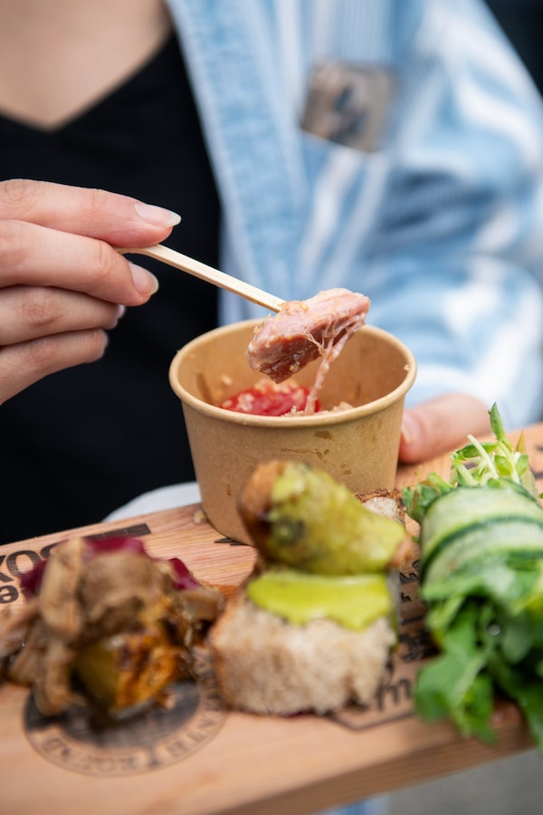 A festivalgoer picks up a bite of the Judge’s pork belly with cherry tomatoes and anchovy breadcrumbs at Brewery & the Beast festival in Toronto on July 26.