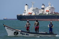 FILE - Fishermen pass an oil tanker in the Gulf of Venezuela off the shore of Punta Cardon, Venezuela, Jan. 14, 2026. (AP Photo/Matias Delacroix, FIle)