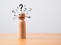 Wooden figure with many questions mark and copy space for doubt suspicion and doodle concept.