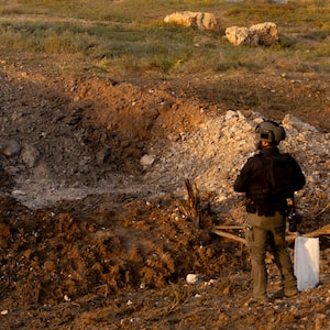 An Israeli police officer surveys the aftermath of an Iranian ballistic missile attack yesterday.