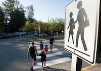Children walk with their parents to Sherwood Park Elementary in North Vancouver for their first day back-to-school on September 10, 2020. THE CANADIAN PRESS/Jonathan Hayward