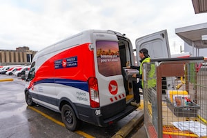 A Canada Post worker fills his truck with mail in Montreal on Tuesday, Dec.17, 2024. THE CANADIAN PRESS/Christinne Muschi