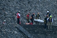 Forensic experts and members of the Red Cross transport a body on the Pyramid of the Moon at the Teotihuacan archaeological zone following a shooting in Teotihuacan, Mexico, on Monday.