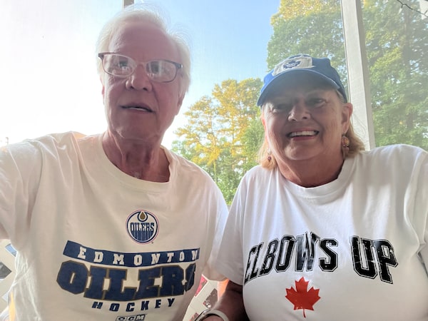 Two people wearing shirts, one says Edmonton Oilers and one says Elbows Up with a Maple Leaf