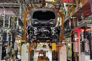 ONLY USE WITH gd-dodge-charger-daytona-plant-12xx: A battery pack is installed in a Charger Daytona. On this part of the line, the Pacificas keep going.